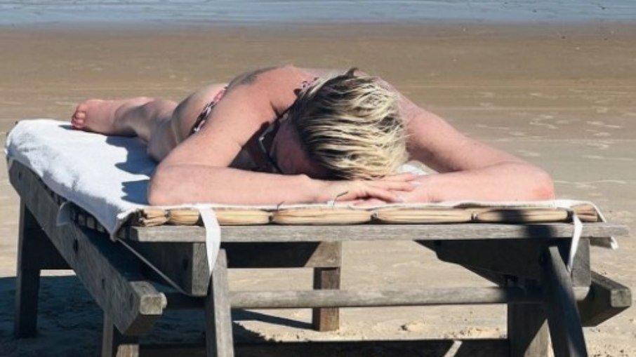 Ana Maria Braga toma sol de biquíni na praia
